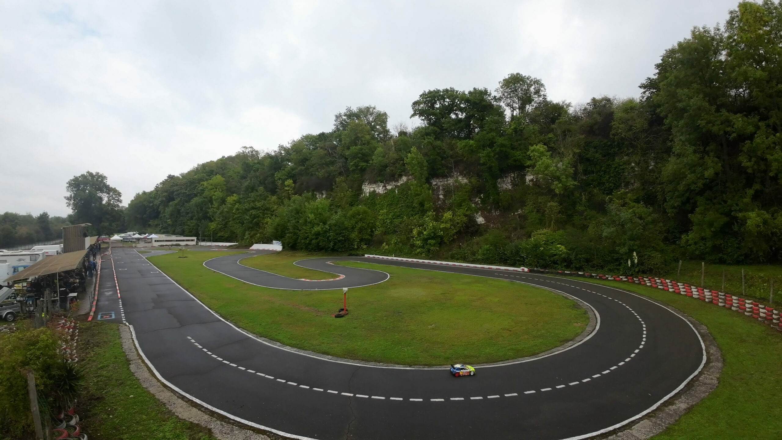 Vue aérienne du circuit de course de voiture RC XR5 à Châteaubourg avec une voiture RC prenant un virage